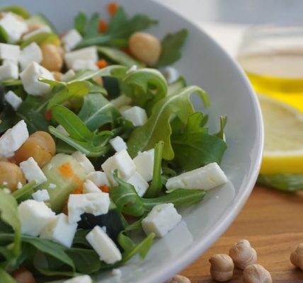 A colorful Mediterranean salad featuring feta, olives, chickpeas, and fresh greens.